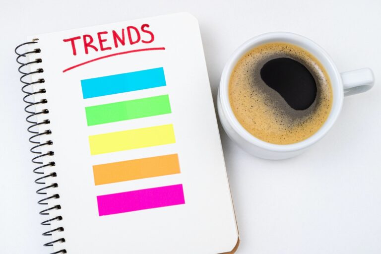 2022 trends business concept. Notebook with trends list, coffee cup on white background
